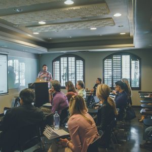 a group of people in a room with a projector screen