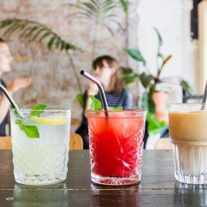 three assorted drinks in glasses with straws