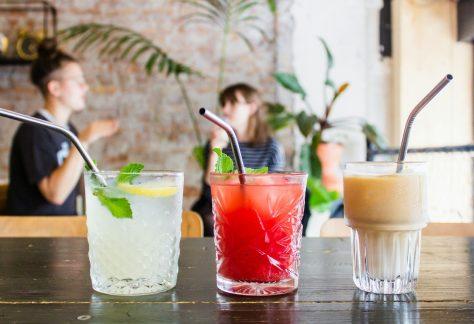 three assorted drinks in glasses with straws